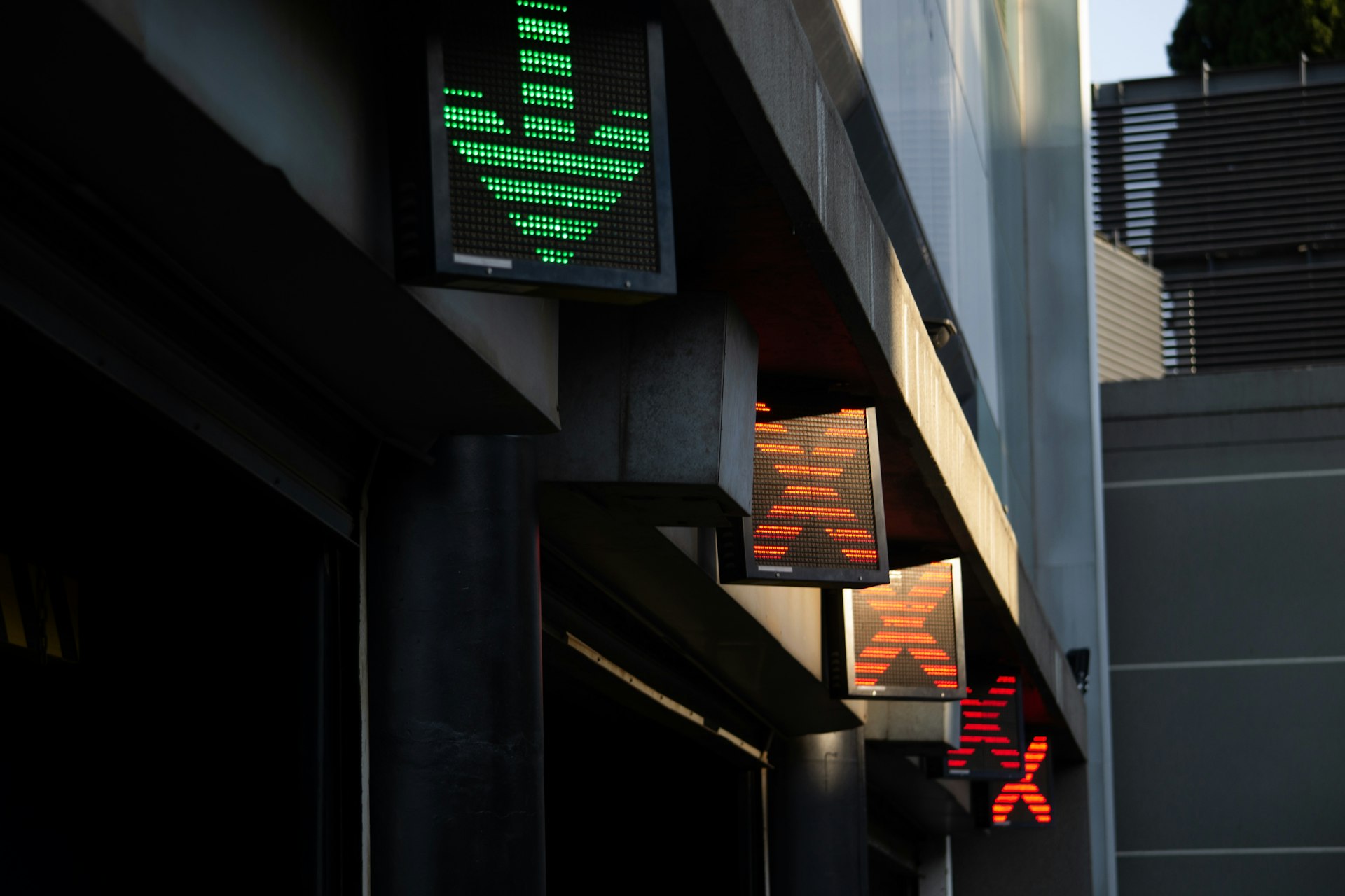 Green arrow and red crosswalk signs on building